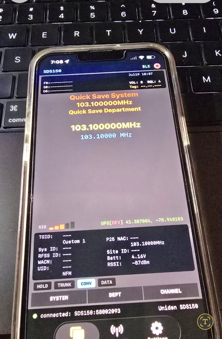 TouchScanner iOS running on an iPhone connected via Bluetooth LE to a live Uniden SDS150, showing 103.100000 MHz tuned in, GPS coordinates, battery voltage (4.16V), and RSSI (-87 dBm)